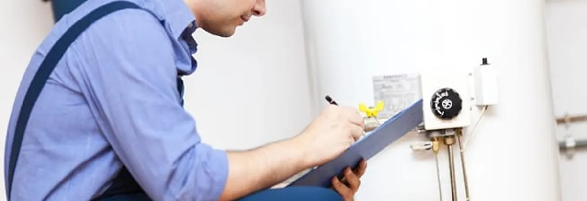 Water heater repair technician inspecting the unit and recording service notes in Nashville, TN